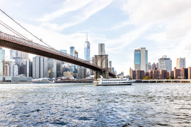 восточная речная вода с видом на нью-йоркский городской пейзаж горизонт, бруклинский мост, паром с судовой лодкой, плавающий на более низки� - ship river east river sky стоковые фото и изображения