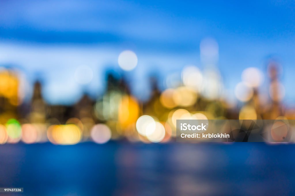 Bokeh di New York City centro del quartiere finanziario inferiore brooklyn bridge grattacieli, east river, skyline del paesaggio urbano durante la sera tramonto blu scuro, crepuscolo, crepuscolo - Foto stock royalty-free di Sfocato