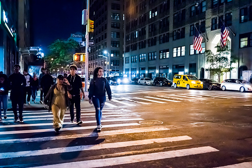 New York City: NYC downtown dark evening night illuminated Charlton street road with traffic cars, people crossing sidewalk in SoHo, Hudson Square neighborhood