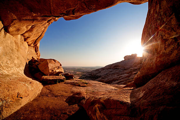 Cave and sunset in the desert mountains stock photo