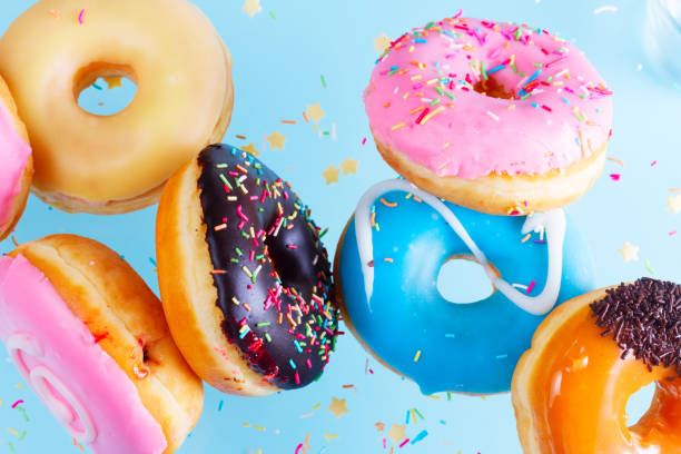 flying doughnuts on blue - candied sugar imagens e fotografias de stock