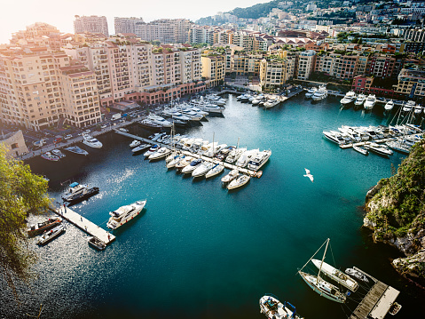 Monte Carlo, Monaco - December 22 2019: panoramic daytime view of Port Hercules, La Condamine and Monte Carlo, with a flag of Monaco