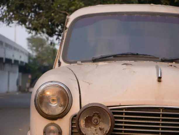 Photo of Rusty white car parked on a street of Chennai, India