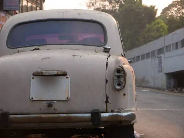 Photo of Rusty white car parked on a street of Chennai, India