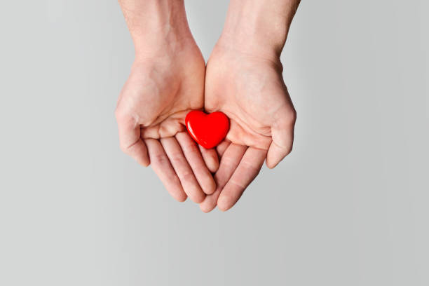 istock Red heart holding in male hands 917451140