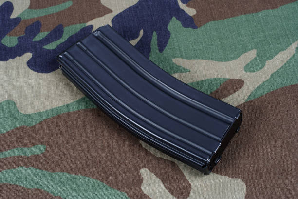 m16 rifle cargador con cartuchos sobre fondo uniforme camuflaje - high capacity magazine fotografías e imágenes de stock
