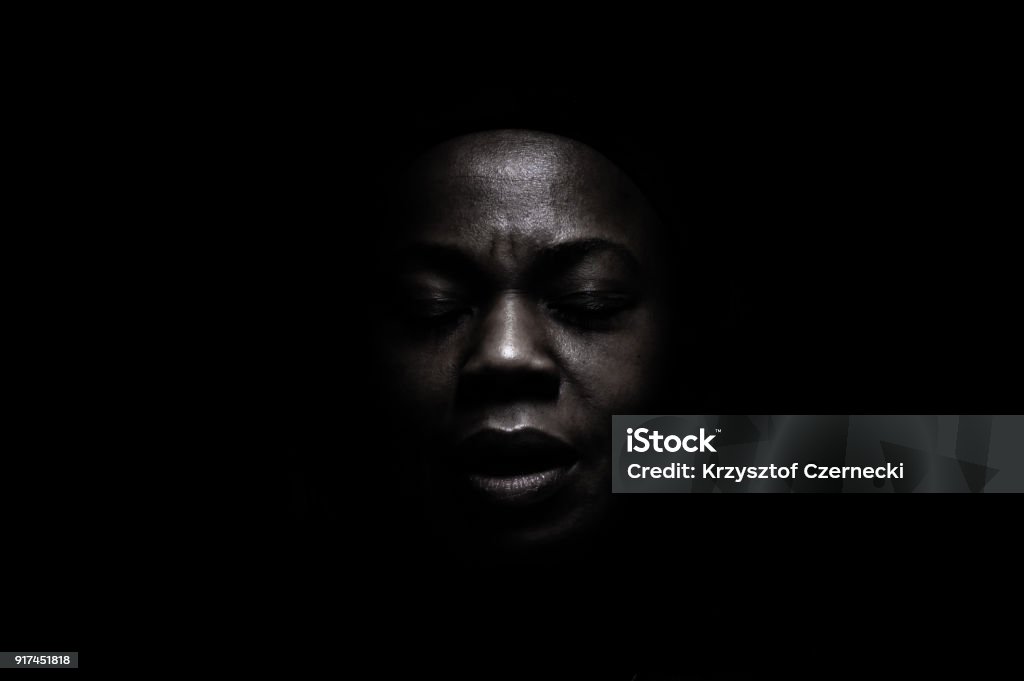 Black face in the shadow Black face in deep shadow , powerful expression. Women Stock Photo