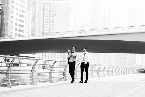 Young modern businessmen are having a walk with beautiful background .Black and white.