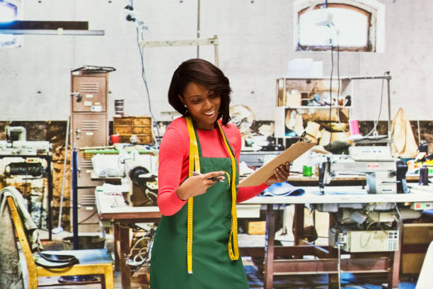 istock Smiling seamstress working in textile shop with clipboard 917455064