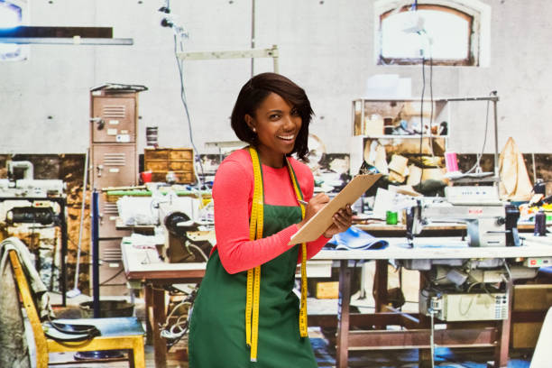 istock Smiling seamstress working in textile shop with clipboard 917455068