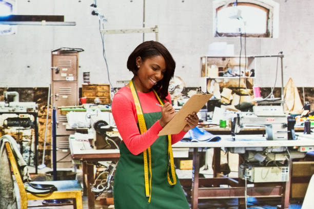 istock Smiling seamstress working in textile shop with clipboard 917455082