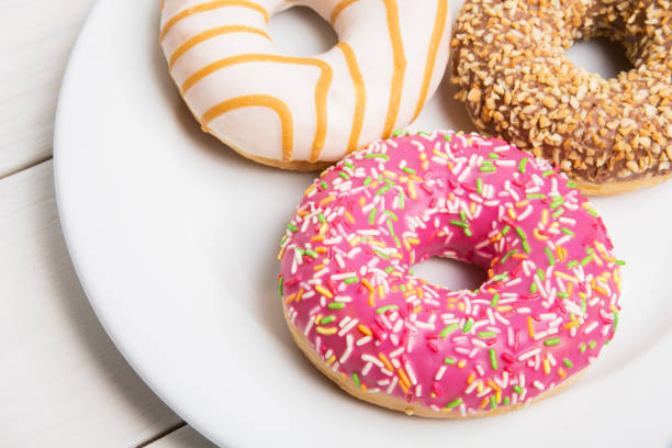 istock Sweet donuts in a glaze on a white plate on a wooden background 917455142