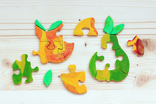 Two wooden puzzles made of coloured pieces. Colorful fruit as a puzzle is a beautiful children's toy