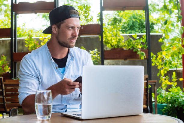 istock Young start up. Handsome business man working at laptop computer, use smartphone 917459322