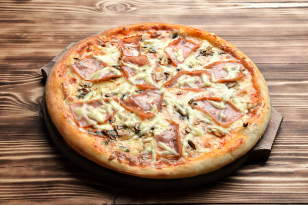 istock Hot big pizza with ham and mushrooms melting cheese bacon tomatoes 917462510