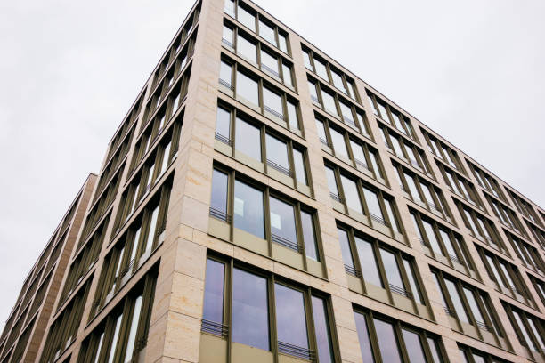 istock low angle view of modern marble colored office building 917465426