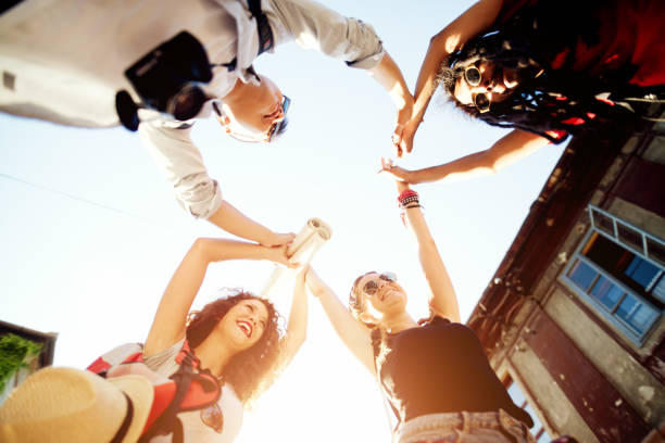 istock Four happy young friends are holding hands in a circle. 917468578