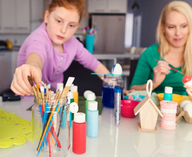 istock Mother and daughter crafting Easter decorations at home. 917471134