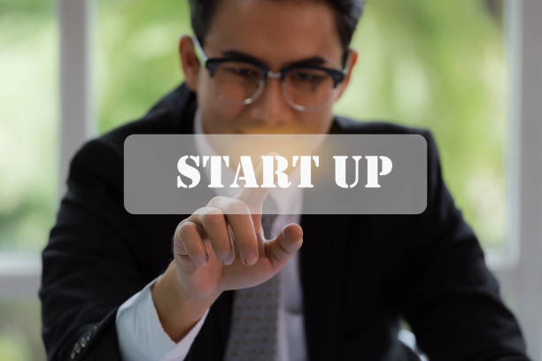 Businessman pushing start up button for business concept with technology element and ecommerce concept.