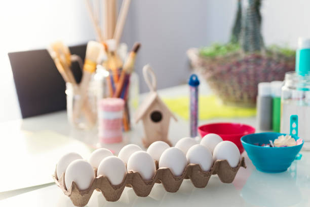Arts and crafts material ready to make Easter decorations at home. Selective focus on eggs. Horizontal indoors waist up shot with copy space. This was taken in Quebec, Canada.