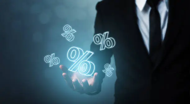 Photo of Interest rate financial and mortgage rates concept. Businessman hand show icon percent 3d sign