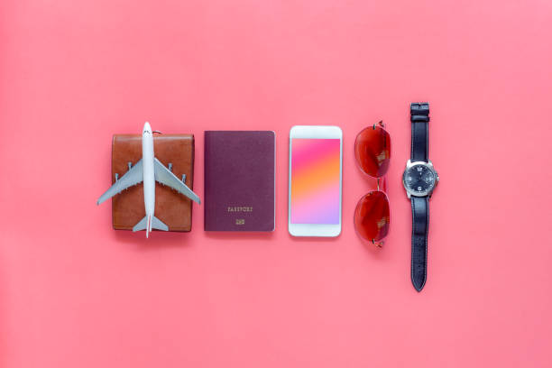 Flat lay image of accessory clothing man or women to plan travel in holiday background concept.Mobile phone & passport with many item in vacation season.Table top view several object on pink paper. stock photo
