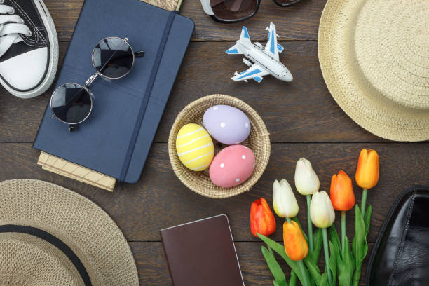 Table top view shot of decoration Happy Easter holiday background concept.Flat lay essential objects plan to travel vacation on modern brown wooden at office desk. Accessory for traveler to trip. stock photo