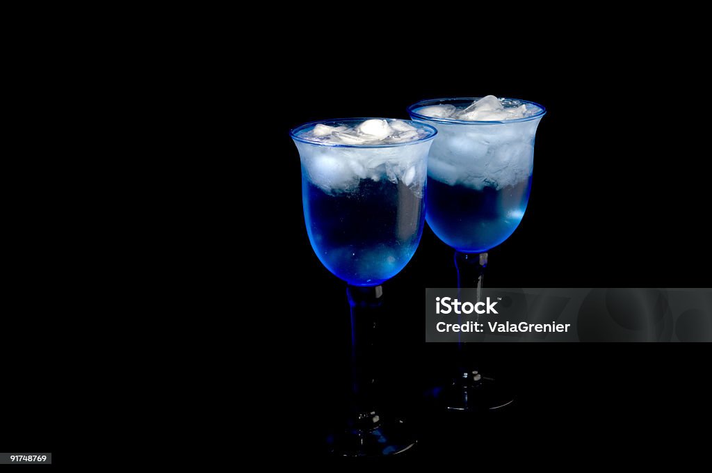 Two blue water glasses on black background.  Blue Glass Stock Photo