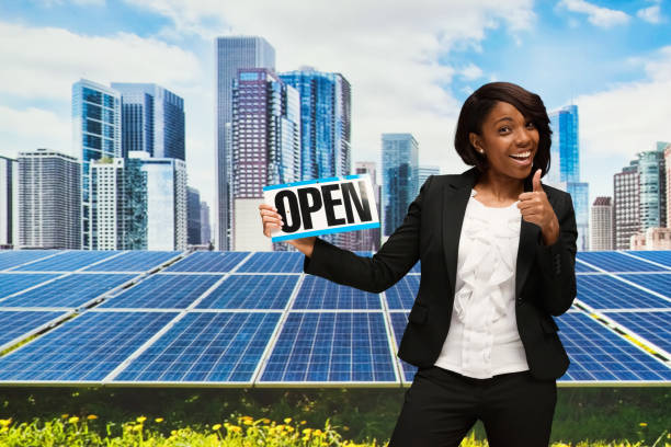 Businesswoman with open sign in front of solar panel