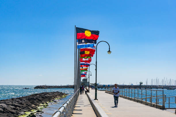 st kilda pier con filas de banderas nacionales con la bandera aborigen australiana - ariel cisjordania fotografías e imágenes de stock