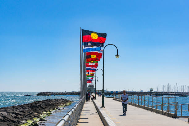 St Kilda Pier with rows of national flags with Australian Aboriginal flag Melbourne, Australia - December 7, 2016: St Kilda Pier with rows of national flags with Australian Aboriginal flag ariel west bank stock pictures, royalty-free photos & images