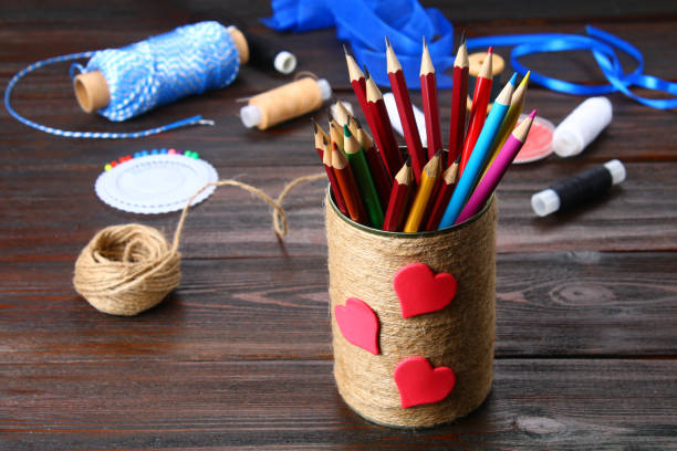 istock Bank for pencils with hearts wrapped with string on a wooden table. Handmade. 917494028