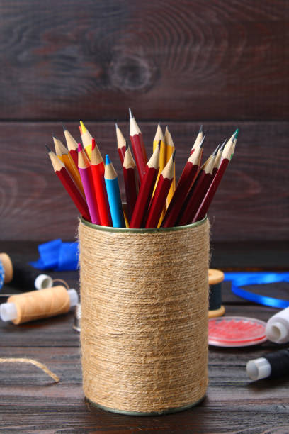 istock Bank for pencils with hearts wrapped with string on a wooden table. Handmade. 917494038