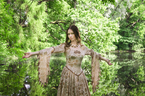 woman in a long vintage dress walks in the Park near the pond
