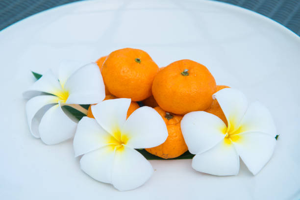 istock Fresh mandarin oranges on white dish decorate with flower 917502442