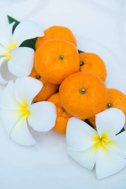 istock Fresh mandarin oranges on white dish decorate with flower 917502470
