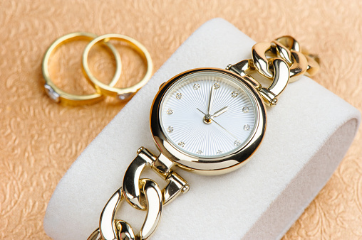 woman accessories, closeup shiny gold women wristwatch