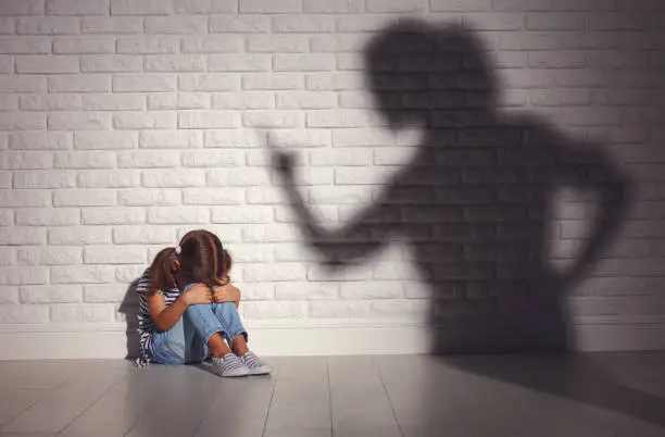 Photo of domestic violence. angry mother scolds   frightened daughter