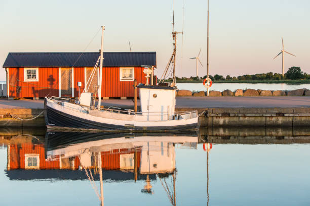 Fishing boat and red Swedish wooden house in Böda hamn; beautiful summer twilights