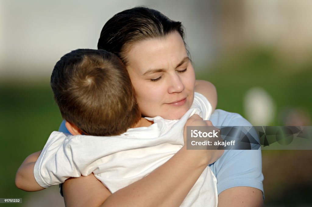 Mother hugging her son tightly Young mother embracing her son with a tight hug Family Stock Photo
