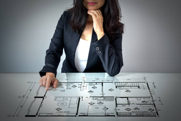 istock Businesswoman (Architect / Interior designer) working with lay out plan on modern futuristic virtual table 917515782