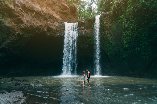 Young Caucasian heterosexual  couple   near   Tibumana waterfall in Bali, Indonesia