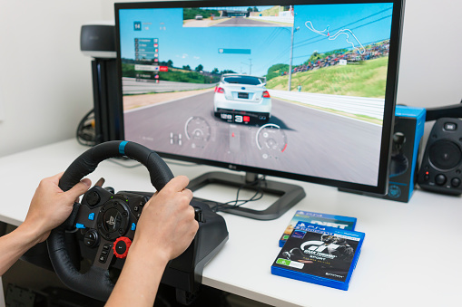 Melbourne, Australia - Jan 30, 2018: A man playing Gran Turismo Sport on PlayStation 4 Pro with steering wheel at home. GT Sport is a popular racing game developed by Polyphony Digital.