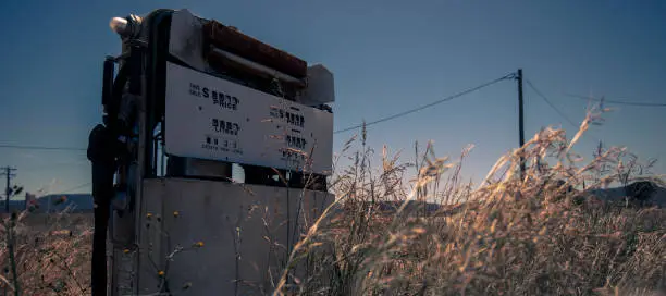 Rusted old fuel pump at the front of an abandoned fuel station.