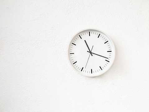 Simple round clock on white wall. Contemporary home decor.