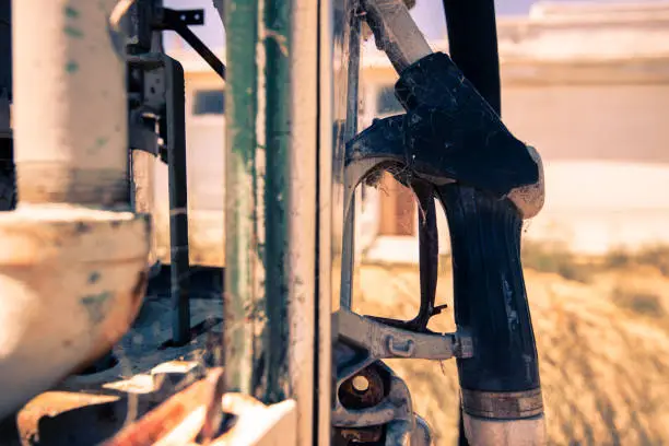 Rusted old fuel pump at the front of an abandoned fuel station.