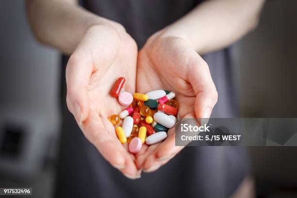Female Holds Pills Of Different Color In Hand Concept Of Health Stock Photo - Download Image Now