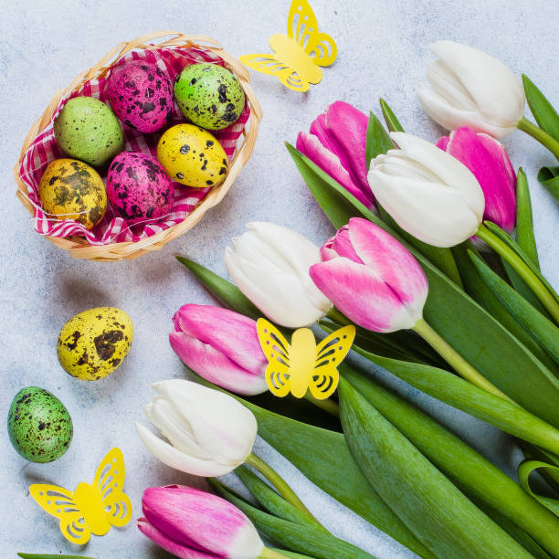 istock Spring Easter Greeting Card. White and pink tulips and colorful quail eggs on stone blue table background. Top view, flat lay, copy space. 917539052