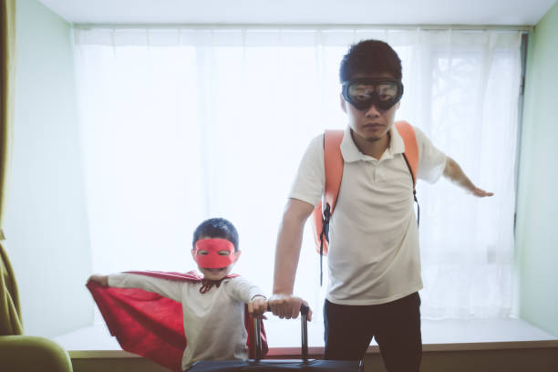 Father and son dressed superhero indoors.