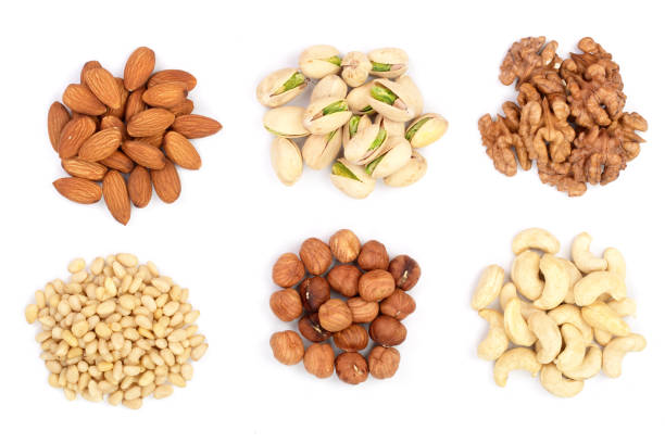 istock mixed of nuts heap isolated on white background. Almonds, cashews, hazelnuts, pine nuts and walnuts. Top view. Flat lay 917557840